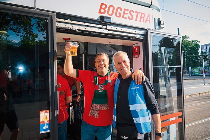 Portugal-Fan mit einem Bogestra-Mitarbeiter vor einem Bus