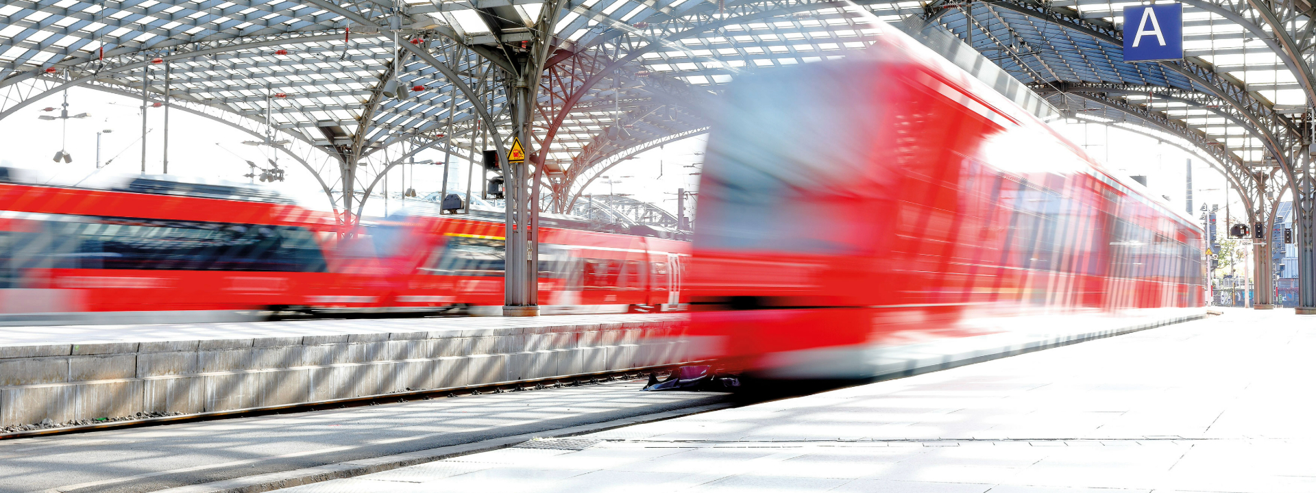 Rote Züge in Bewegung auf einem modernen Bahnhof.