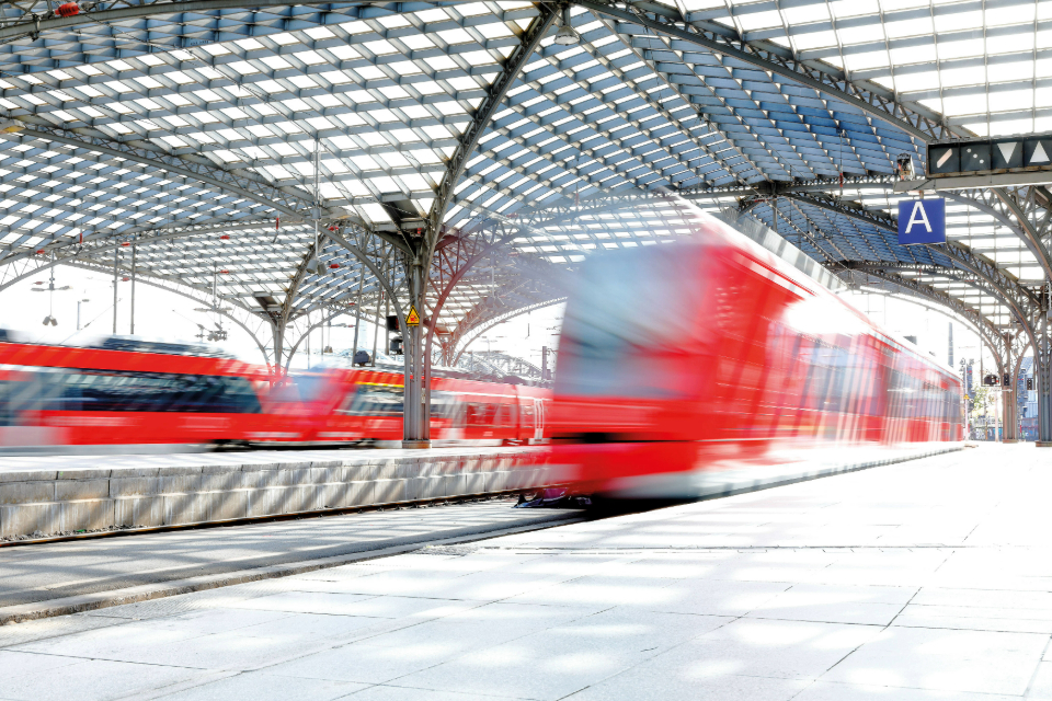 Rote Züge in Bewegung auf einem modernen Bahnhof.